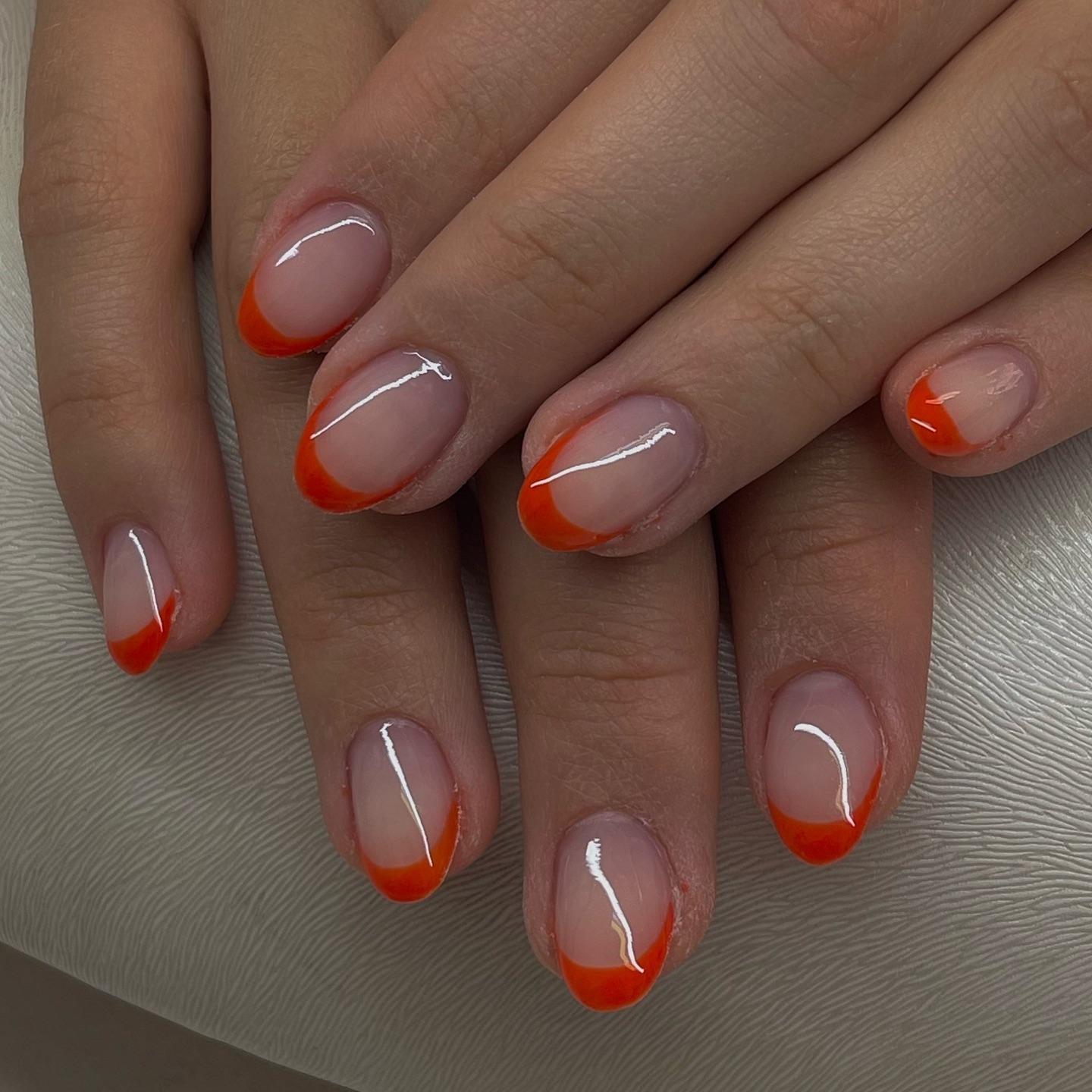 French Nails mit orangefarbener Spitze und feiner weißer Linie