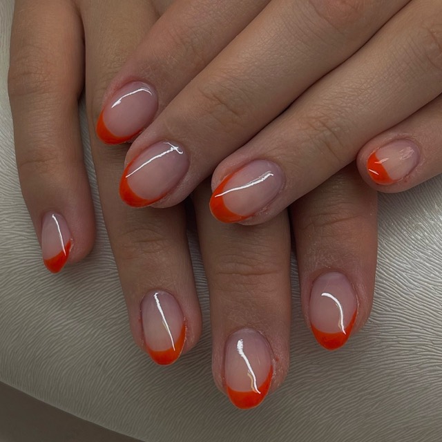 French Nails mit orangefarbener Spitze